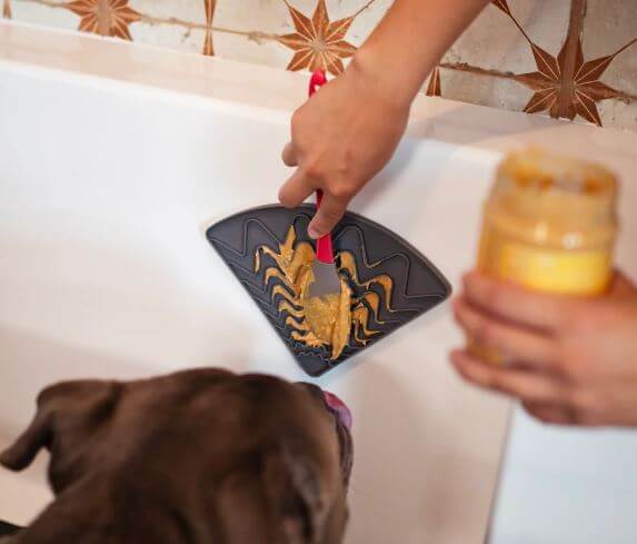 Messy Mutts Lick Mat being used in the tub to show product use and detail 